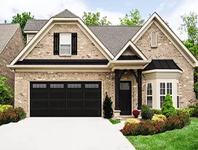 Black residential garage door on a brick home